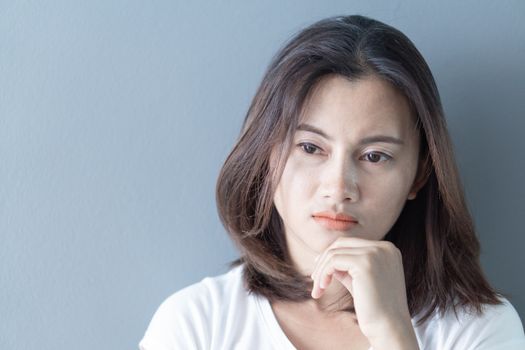 Closeup woman sitting on bed in the bedroom with thinking or depressed feeling, selective focus