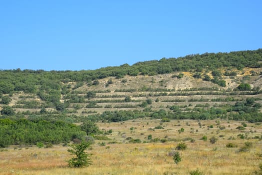 Landscapes of Crimean nature. Fields and hills visible from car window from the road.