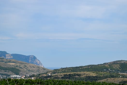 Landscapes of Crimean nature. Fields and hills visible from car window from the road.