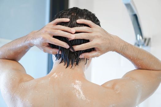 Closeup handsome asian man taking a shower in the bathroom, selective focus