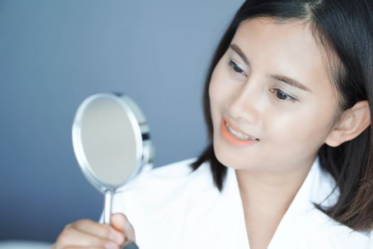 Close up face of woman looking the mirror with happy feeling, health care and beauty concept