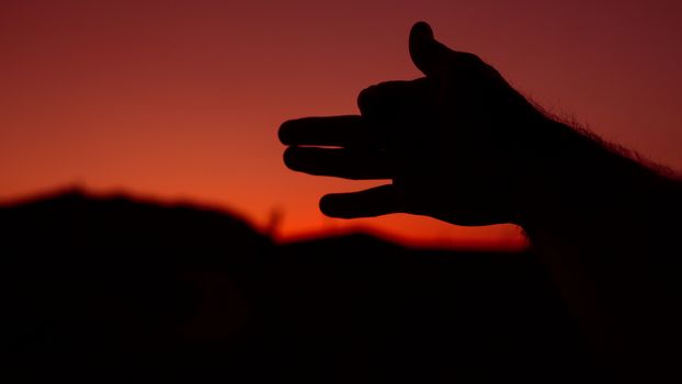 Silhouette of a hand at sunset