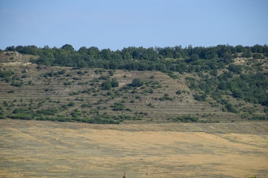 Landscapes of Crimean nature. Fields and hills visible from car window from the road.