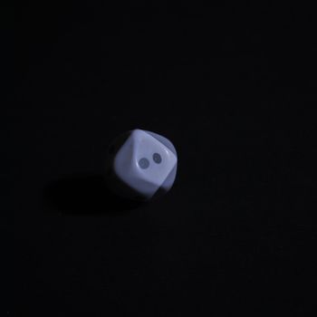 Dice, on black background, in motion, long exposure