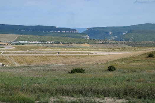 Landscapes of Crimean nature. Fields and hills visible from car window from the road.