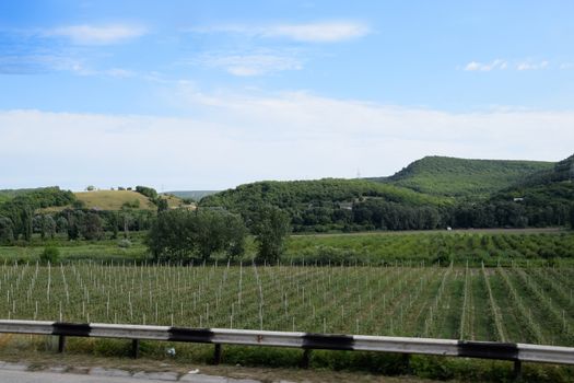 Landscapes of Crimean nature. Fields and hills visible from car window from the road.