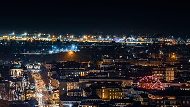 Night lights on the city of Bergamo, image of the Ferris wheel set up for the holidays