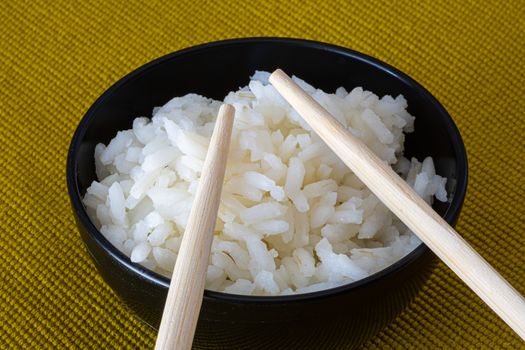 Rice bowl with Chinese chopsticks on a light background