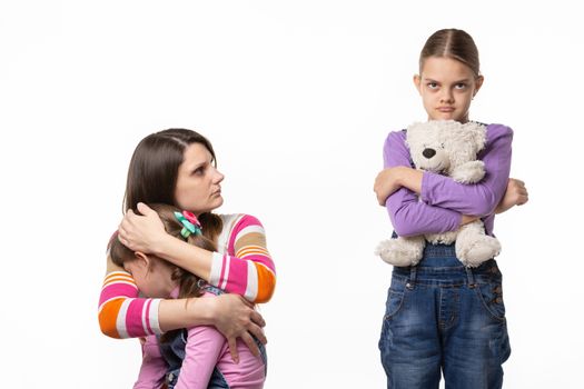 Mom reproachfully looks at the eldest daughter for offending the younger daughter