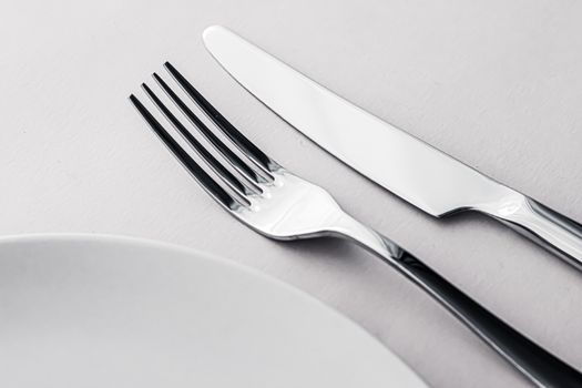 Empty plate and cutlery as mockup set on white background, top tableware for chef table decor and menu branding design