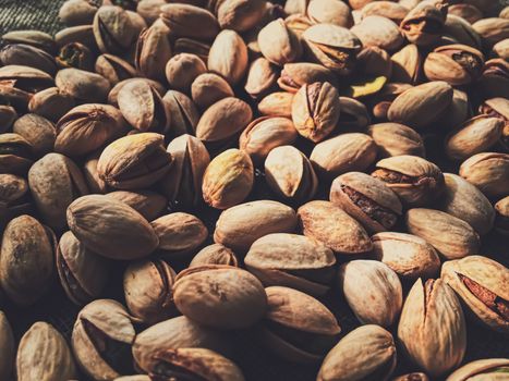 Pistachio nuts on rustic linen background, food and nutrition