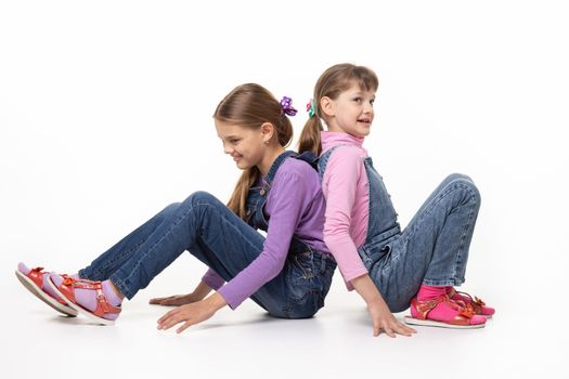 Children sitting on the floor pushing their backs