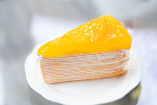 Closeup Orange cake delicious on glass table background, selective focus