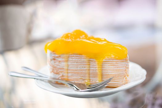 Closeup Orange cake delicious on glass table background, selective focus