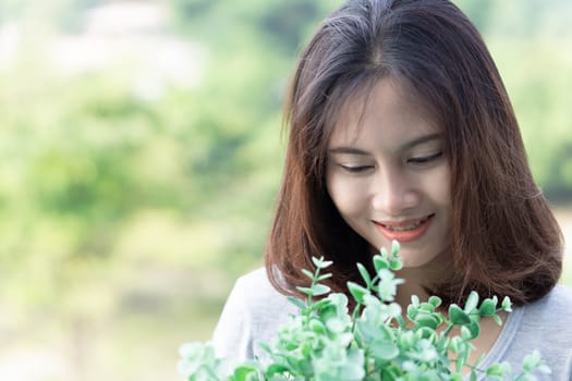 Closeup woman touching tree in pot with happy face in the morning