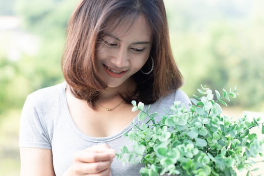 Closeup woman touching tree in pot with happy face in the morning