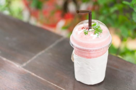 Closeup  strawberry smoothie with green nature background, selective focus