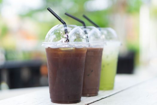Close up glass of ice matcha green tea and ice coffee on wood table, selective focus
