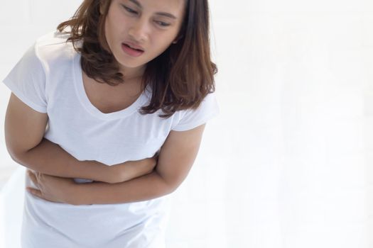 Close up woman stomachache with toilet in the morning, health care concept, selective focus