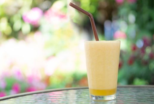 Closeup passion fruit smoothie  with green nature background, selective focus