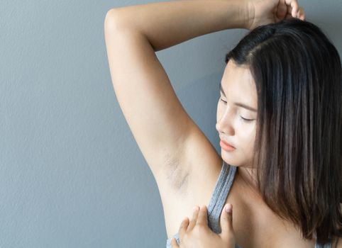 Women problem black armpit lying on white bed background for skin care and beauty concept, selective focus