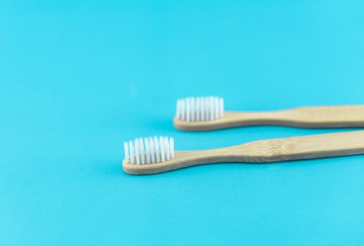 Close up wooden toothbrush on blue background, selective focus