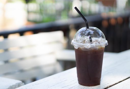 Close up glass of ice americano coffee on wood table, selective focus