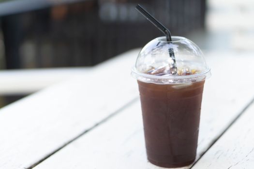 Close up glass of ice americano coffee on wood table, selective focus