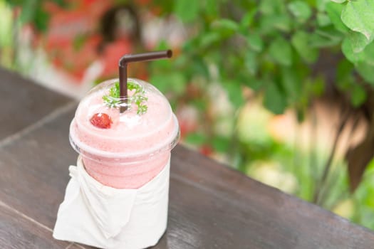 Closeup  strawberry smoothie with green nature background, selective focus