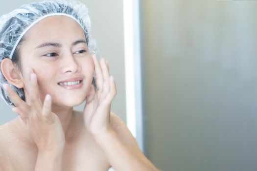 Close up woman looking her face in the mirror with smiling after bath, health care and beauty