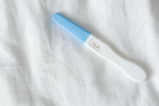 Pregnancy test on white bed background, health care and medical concept