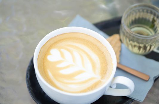 Closeup glass of latte art coffee tulip shape on wood background with vintage color, selective focus