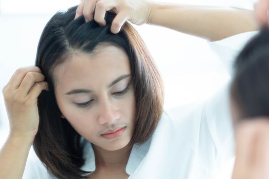 Woman looking reflection in the mirror serious hair loss problem for health care shampoo and beauty product concept