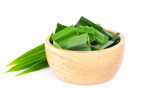 Fresh green pandan leaves with slice in wood bowl isolated on white background