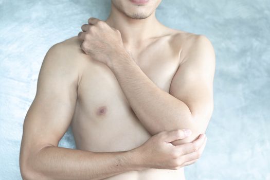 Closeup man hand holding elbow with pain with grey background, health care and medical concept