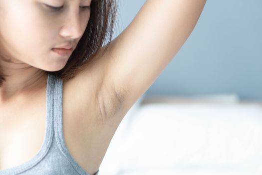 Women problem black armpit lying on white bed background for skin care and beauty concept, selective focus