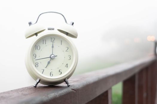 Alarm clock with nature and fog background in the morning