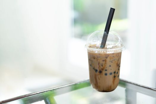 Closeup glass of ice americano on wood table in coffee shop