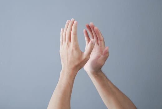 Man clapping hands on grey background