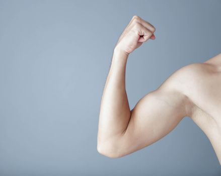 Man arm with muscle on grey background, health care and medical concept