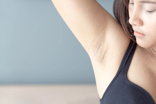 Women problem black armpit lying on white bed background for skin care and beauty concept, selective focus