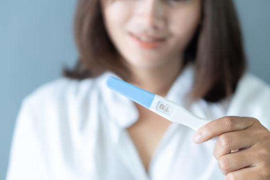 Closeup woman hand holding pregnancy test with happy moment, health care concept, selective focus