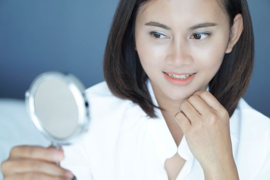 Close up face of woman looking the mirror with happy feeling, health care and beauty concept