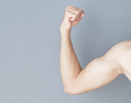 Close up arm muscle man with grey background, health care and medical concept