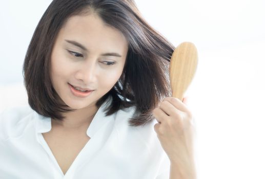 Woman looking reflection in the mirror serious hair loss problem for health care shampoo and beauty product concept