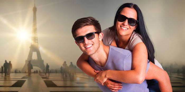 Man giving his pretty girlfriend a piggy back against eiffel tower