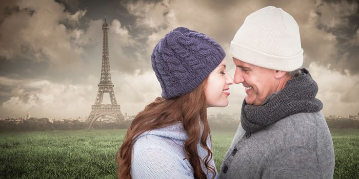Couple in warm clothing facing each other against paris under cloudy sky