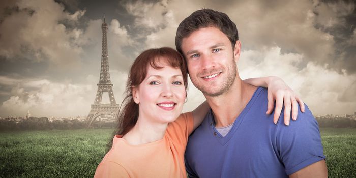 Couple looking at the camera against paris under cloudy sky