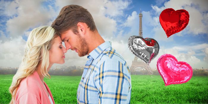 Attractive couple standing touching heads against eiffel tower