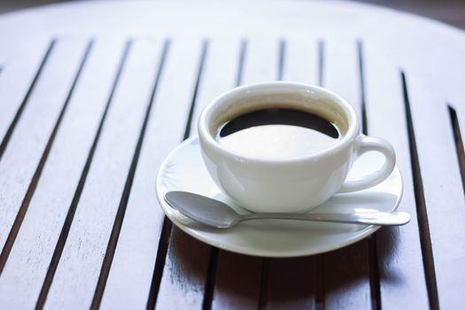Closeup glass of hot americano coffee on wood table, selective focus, vintage tone